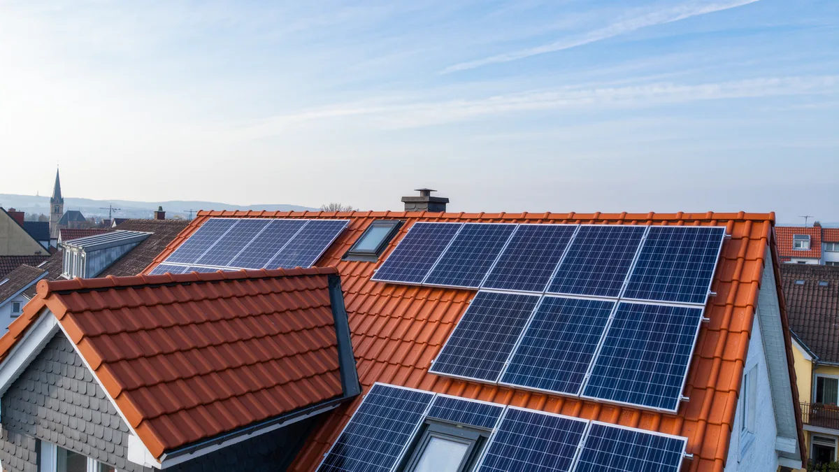 Symbolbild: Photovoltaikmodule auf dem Ziegeldach eines Wohnhauses
