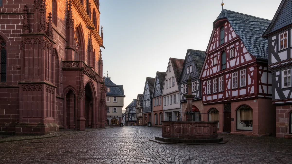Symbolbild: menschenleerer Altstadtplatz mit Sandsteinfassade und Fachwerkhäusern